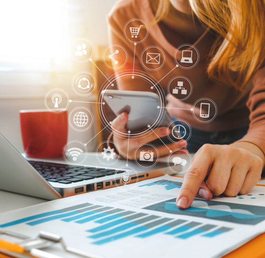 a woman using a laptop and a phone checking different services for a marketing strategy