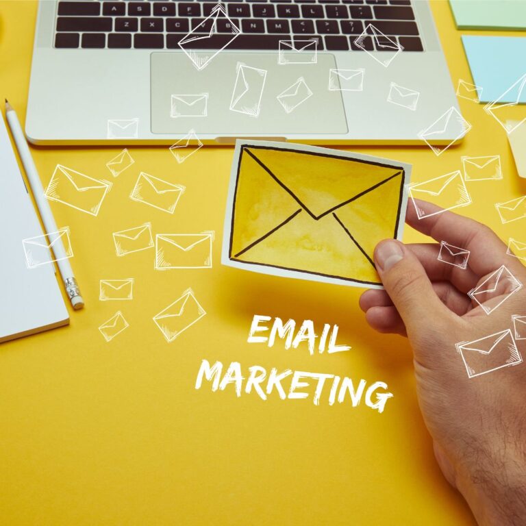 a hand holding a small yellow envelope for email marketing checklist